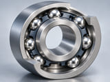 Conceptual CGI: compact stainless bearing assembly cutaway with polished balls, realistic closed circular inner and outer raceways