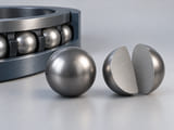Conceptual CGI: grey niobium sphere next to a carefully separated hemispherical cutaway showing solid homogeneous metal and clean surface; no superconductivity graphics