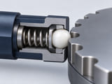 Conceptual CGI: Cutaway compact low-load indexing detent with a white acetal sphere, small visible spring, metal housing and grooved mating plate; no force arrows or labels