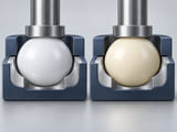 Conceptual CGI: White POM sphere in a light mechanical seating cup next to an ivory nylon sphere in a second matching cup; clear running clearance and polished contact geometry, no test claims