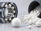 Conceptual CGI: White dense precision alumina sphere beside a small pile of rougher white ceramic milling beads; distinguish precision component and process media with clear surface difference, no labels